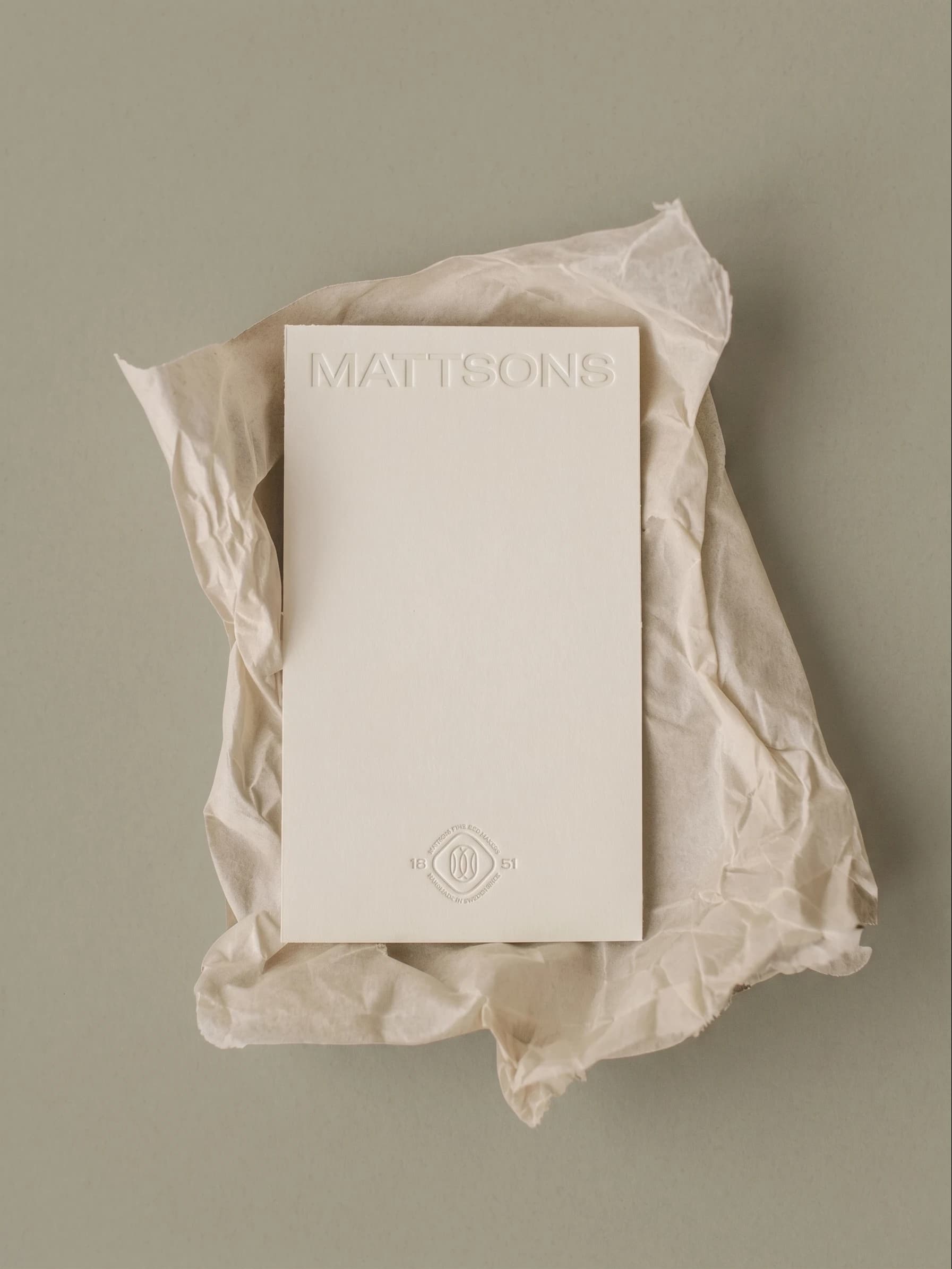 Mattsons wordmark on a card resting on crumpled tissue paper